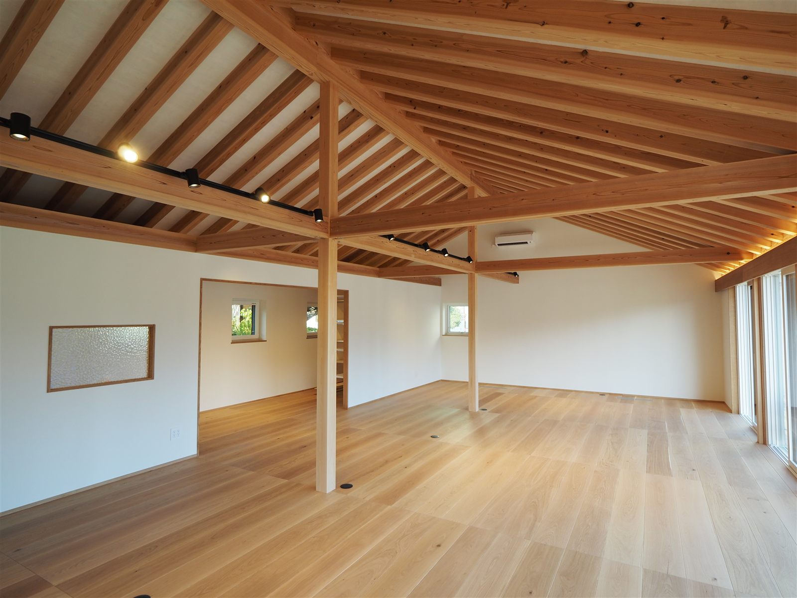 登り梁あらわしの天井と無垢床の大空間の平屋店舗